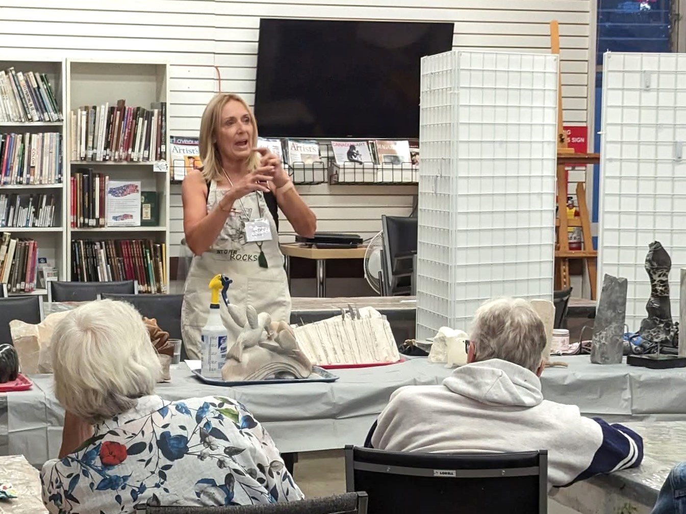 Instructor giving a live art demonstration to a seated audience.
